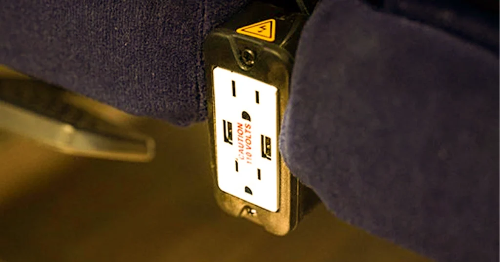 Power outlet installed on charter bus seat for charging